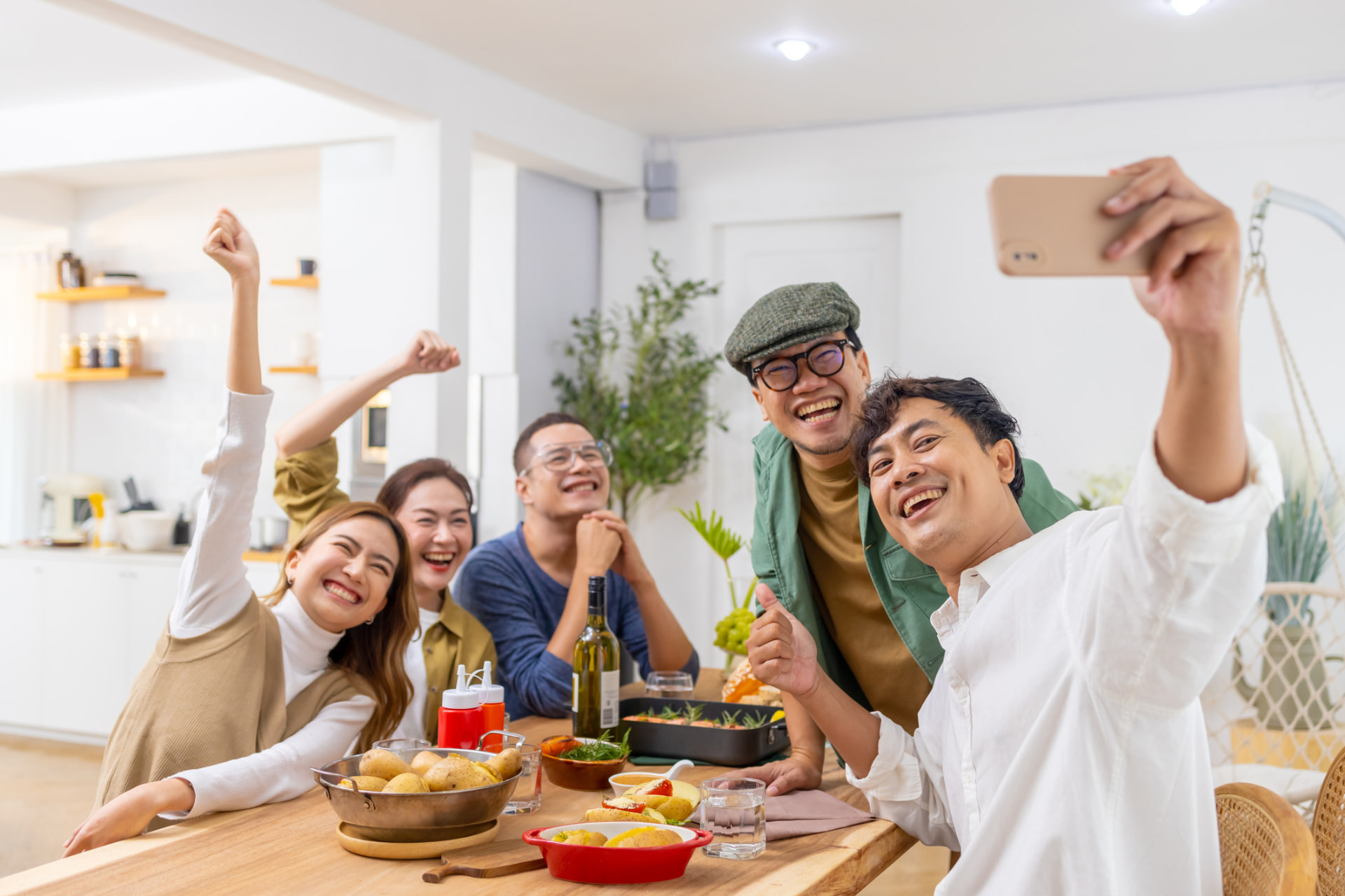 Housemates laughing and taking a selfie over dinner at home